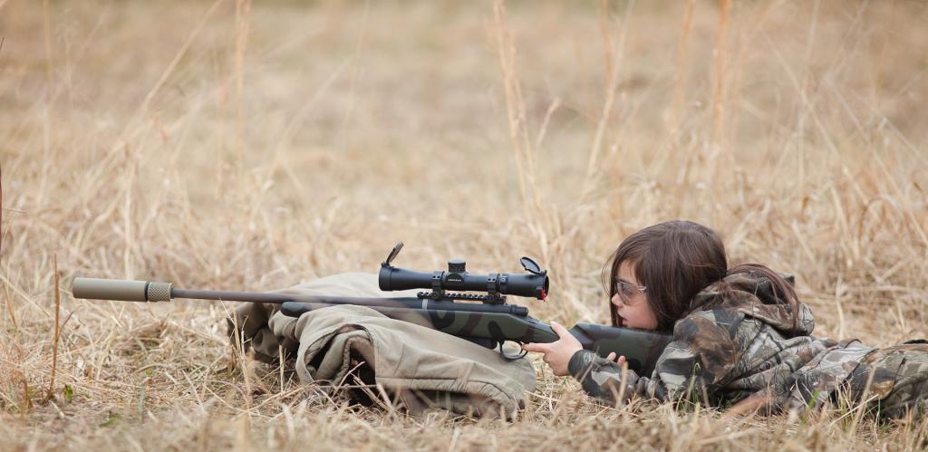 Девушка пристреливает винтовку.